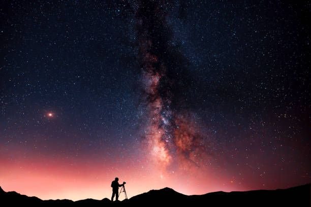 beautiful-starry-night-landscape-a-silhouette-of-a-photographer-stands-on-a-hill-and-looks-at8050632085789919497.jpg