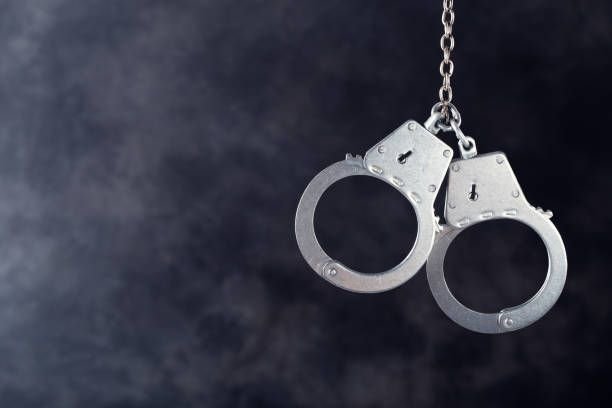 handcuffs-hanging-on-dark1679397823475959572.jpg