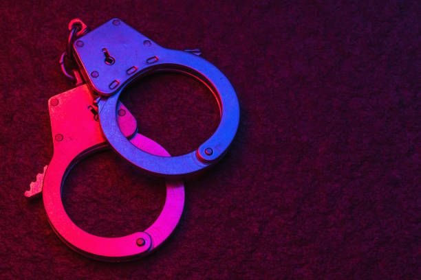 handcuffs-on-dark-background-illuminated-by-flashing-lights-of-police-car-with-copy-space4171631560898488152.jpg