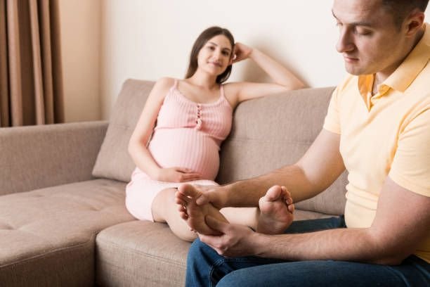 happy-pregnant-family-husband-massaging-his-pregnant-wife-legs-and-sitting-together-on-couch1737698716443619928.jpg
