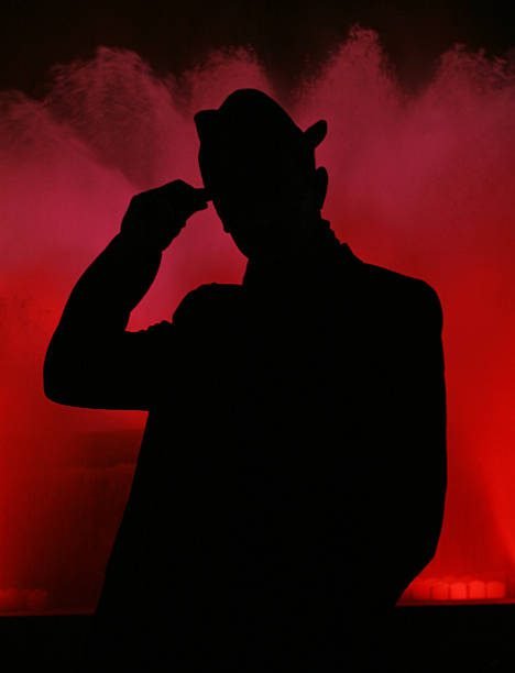 Man’s silhouette on red fountain.