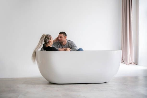 man-and-woman-engaging-in-conversation-while-sitting-at-opposite-ends-of-a-modern-bathtub7492800719158170722.jpg